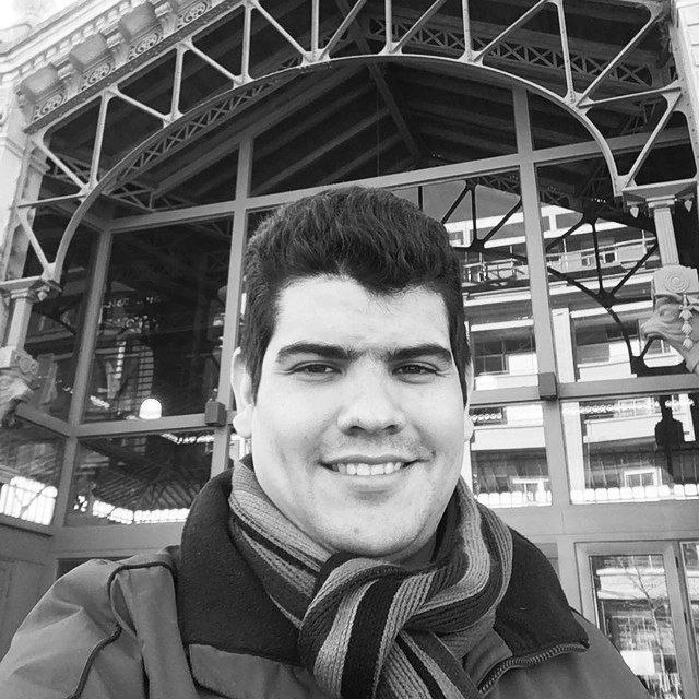 Retrato en blanco y negro del Ing. Hernán J. Rosas M., fundador de HPI, sonriendo, con arquitectura de cristal al fondo.